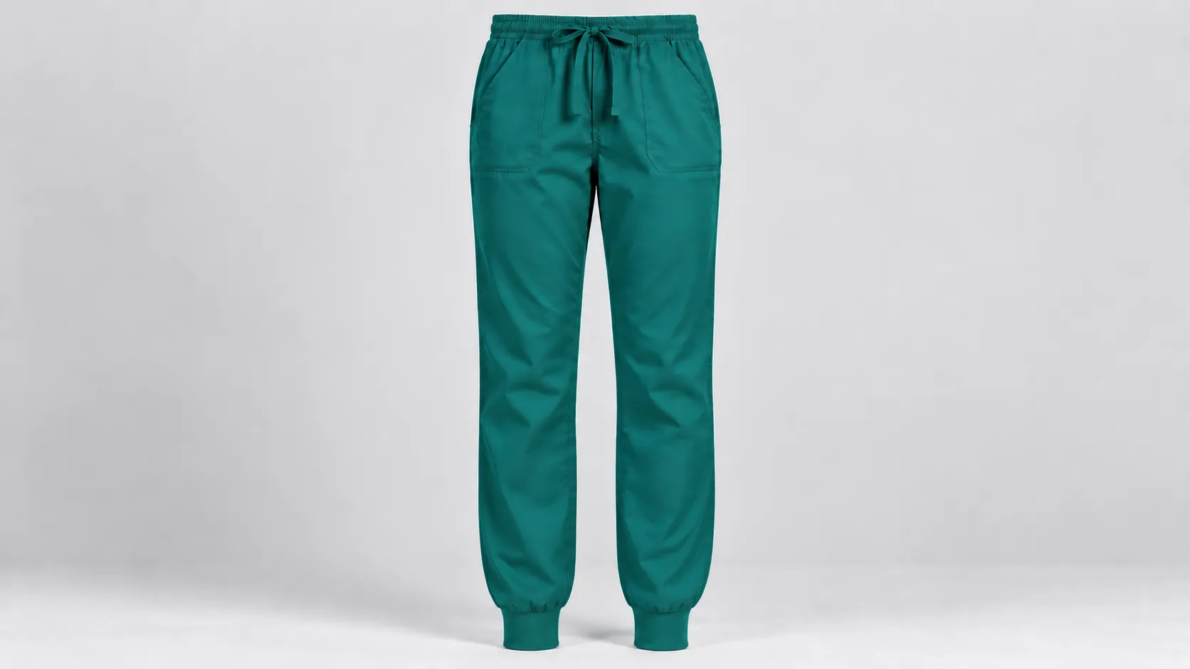 Teal scrub jogger pants featuring fitted knit cuffs, a drawstring waistband and front patch pockets.